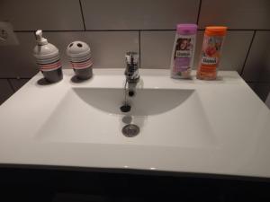 a white bathroom sink with two bottles of toothpaste at Au Coup de Cœur in Colmar +24 photos