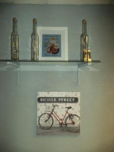 a shelf with a bike and four bottles on it at Au Coup de Cœur in Colmar