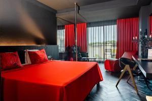 a hotel room with a red bed and a desk at The X Belek in Belek