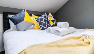 a bedroom with a white bed with colorful pillows at Quiet Top-Floor Retreat -Modern Studio for 2 - Islington in London