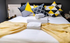a bed with pillows and towels on it at Quiet Top-Floor Retreat -Modern Studio for 2 - Islington in London