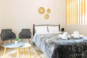 a bedroom with a bed and two chairs at P&K LUXURY APARTMENTS 3 in Kalamata