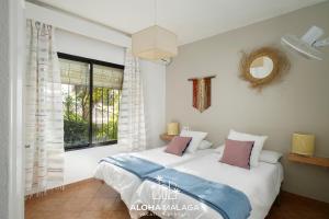 a bedroom with two beds and a window at LaCalma Village with private pool By AlohaMálaga in Málaga +47 photos
