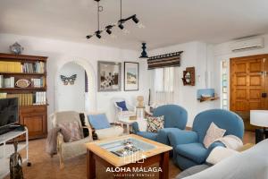 a living room with blue chairs and a table at LaCalma Village with private pool By AlohaMálaga in Málaga