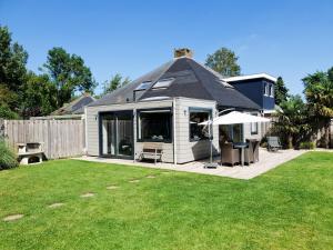 a house with a patio and a yard at Holiday cottage with sauna in Zeeland in Stavenisse