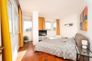 a bedroom with a bed and a television in it at Perla Marina Sea View Apartment in Catania