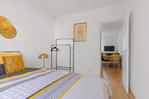 a bedroom with a bed and a dining room at T2 cosy - stationnement gratuit in Bourg-en-Bresse