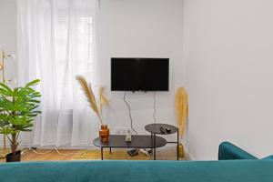 a living room with a blue couch and a tv at T2 cosy - stationnement gratuit in Bourg-en-Bresse +5 photos