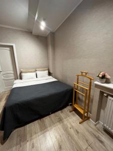 ein kleines Schlafzimmer mit einem Bett und einem Tisch in der Unterkunft Квартира в центральній частині Луцька in Luzk