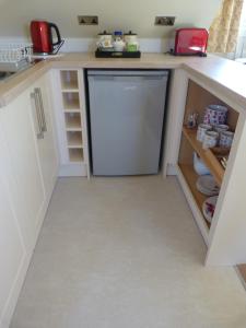 a kitchen with a dishwasher and a refrigerator at Glen House Annexe in Bourne