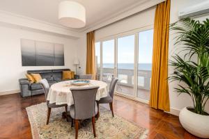 a living room with a table and a couch at Perla Marina Sea View Apartment in Catania