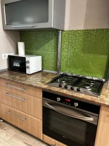 eine Küche mit Herd und Mikrowelle in der Unterkunft Квартира в центральній частині Луцька in Luzk