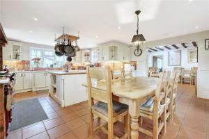 a kitchen and dining room with a wooden table and chairs at Blackbrook Farmhouse in Colchester