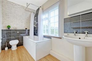 a bathroom with a sink and a tub and a toilet at Blackbrook Farmhouse in Colchester +19 photos