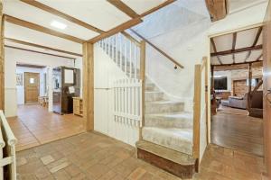 a staircase in a house with a living room at Blackbrook Farmhouse in Colchester
