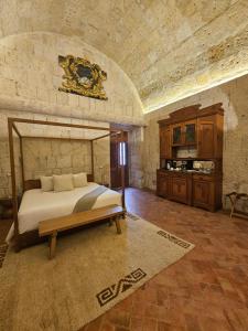 a bedroom with a large bed in a stone wall at Palacio Guaqui by Ananay Hotels in Arequipa