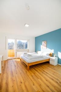 a bedroom with a large bed and a wooden floor at Gemütliche, moderne Ferienwohnung in Stadtnähe in Würzburg