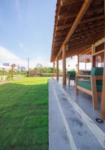 a pavilion with benches and a field of grass at Casa Licuri Corumbau in Corumbau