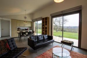 un salon avec un canapé et une table dans l'établissement Maison bioclimatique, à Meyrals