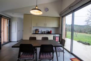 une cuisine et une salle à manger avec une table et des chaises dans l'établissement Maison bioclimatique, à Meyrals 1 autre photo