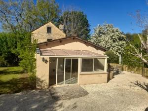 ein Haus mit einem Sonnendach auf einer Auffahrt in der Unterkunft La colombelle in Carsac-Aillac