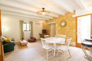 ein Esszimmer und ein Wohnzimmer mit einem weißen Tisch und Stühlen in der Unterkunft La colombelle in Carsac-Aillac