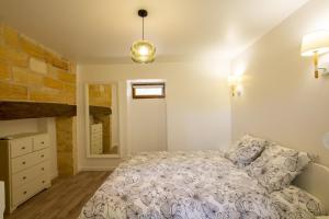 ein Schlafzimmer mit einem Bett und einer Steinwand in der Unterkunft La colombelle in Carsac-Aillac