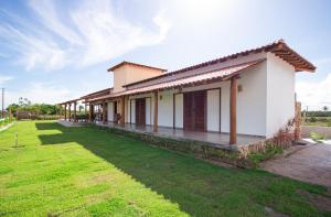 a house with a green lawn in front of it at Casa Licuri Corumbau in Corumbau