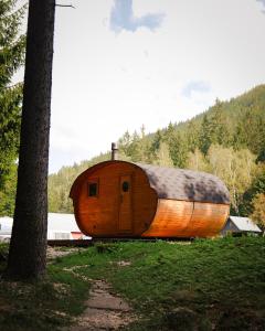 a large wooden boat sitting in a field next to a tree at Chalets & Apartments - Base Camp Medvědín in Špindlerův Mlýn +63 photos