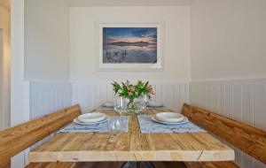 una sala da pranzo con tavolo in legno e fiori di Curlew Cottage a Gatehouse of Fleet