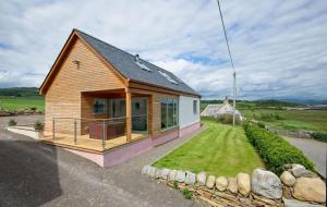 una piccola casa con portico e cortile di Curlew Cottage a Gatehouse of Fleet