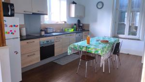 a kitchen with a table with a table cloth on it at Les rosieres 2 in Dom-le-Mesnil