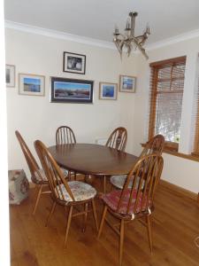 a dining room with a wooden table and chairs at Dullatur in Newtonmore +11 photos