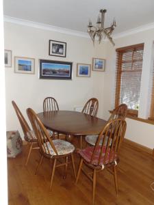 a dining room with a wooden table and chairs at Dullatur in Newtonmore