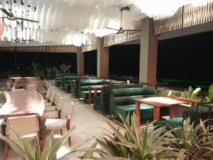a restaurant with green chairs and tables and plants at Izotal Bioluxury Hotel in Taminango