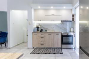 a kitchen with white cabinets and a stove at P&K LUXURY APARTMENTS 2 in Kalamata