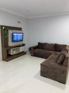a living room with a couch and a flat screen tv at Ap novo ótima localização na avenida principal in Piratuba +15 photos