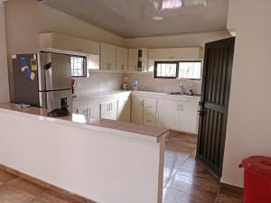 a large kitchen with white cabinets and a refrigerator at Finca la mariana in Pereira