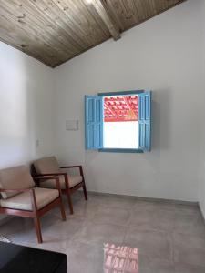 Casa Vista Monte Pascoal في بورتو سيغورو: غرفة معيشة مع كرسيين ونافذة