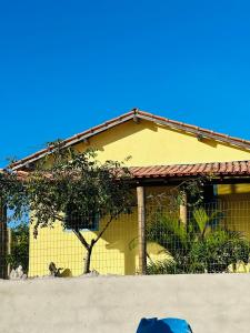 Casa Vista Monte Pascoal في بورتو سيغورو: منزل اصفر امامه شجره