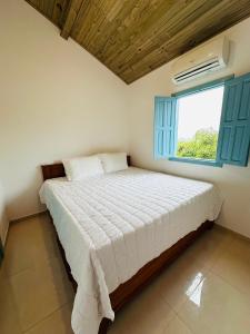 Casa Vista Monte Pascoal في بورتو سيغورو: غرفة نوم بسرير كبير مع نافذة
