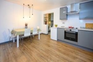 a kitchen with a table and chairs and a kitchen withuclear at LITTLE COTO Fully Equipped South West Home By STAE-Homes in Bristol +24 photos