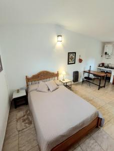 a bedroom with a large bed and a table at Rumihuasi Apartamento in Los Reartes +11 photos