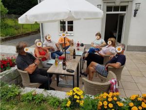 a group of people sitting at a table wearing face masks at Alte Leimsiederei in Herrnhut
