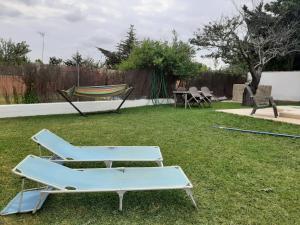 two chairs and a hammock in a yard at Casa El Veranito in Chiclana de la Frontera