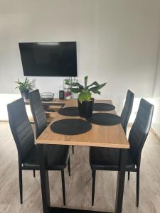 einen Esstisch mit Stühlen und einen TV in der Unterkunft Apartament z tarasem in Sanok