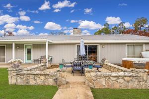 a house with a stone retaining wall and a patio at Arrowhead Falls in Wimberley