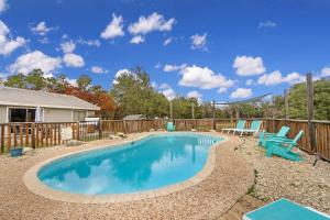 a swimming pool with chairs and a fence at Arrowhead Falls in Wimberley
