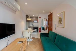 a living room with a green couch and a table at City Life in Setubal