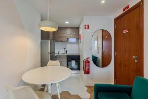 a small kitchen with a white table and chairs at City Life in Setubal